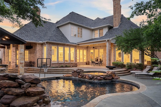 pool at dusk with a patio area
