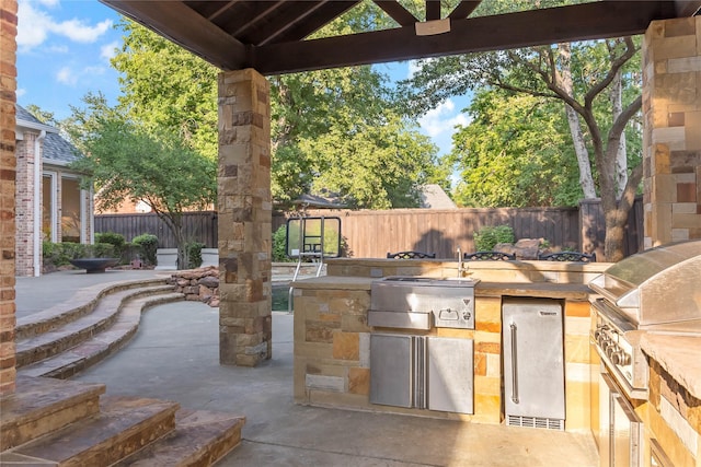 view of patio / terrace featuring fence, area for grilling, and a grill