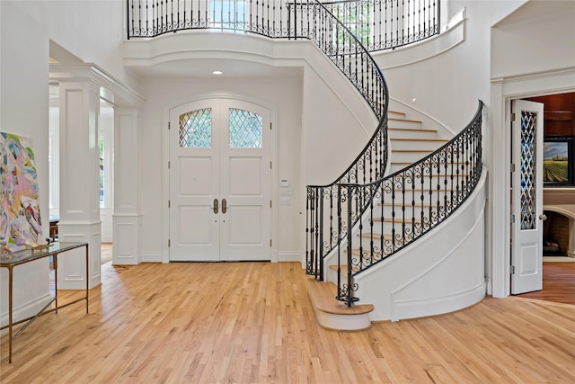 entryway with a high ceiling, wood finished floors, and stairway