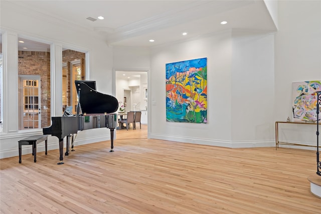 living area with crown molding, baseboards, and wood finished floors