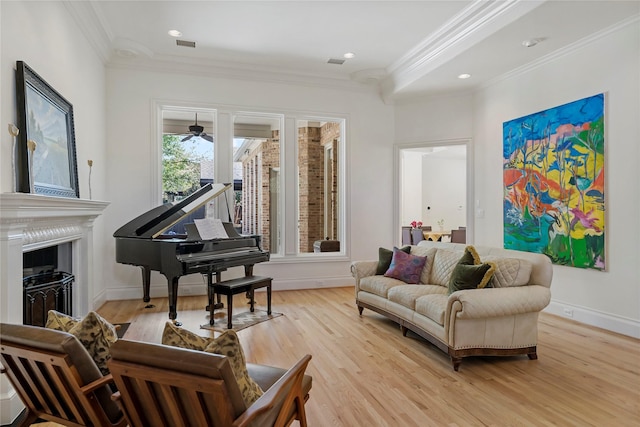 sitting room featuring crown molding, light wood finished floors, baseboards, and a fireplace