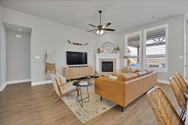 1920 Barnhill Ln, Van Alstyne, TX 75495 - living area featuring light wood-type flooring, ceiling fan, baseboards, and a glass covered fireplace