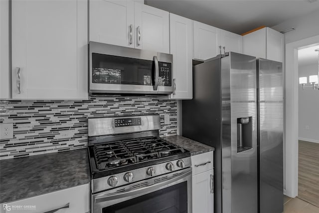 kitchen with appliances with stainless steel finishes, decorative backsplash, and white cabinetry