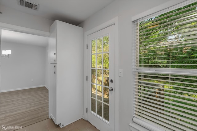 entryway featuring light wood-style flooring, baseboards, and visible vents