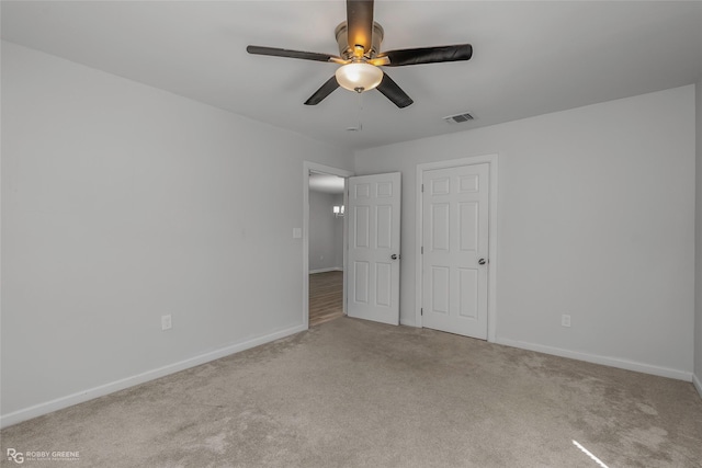 unfurnished bedroom featuring baseboards, carpet, and visible vents