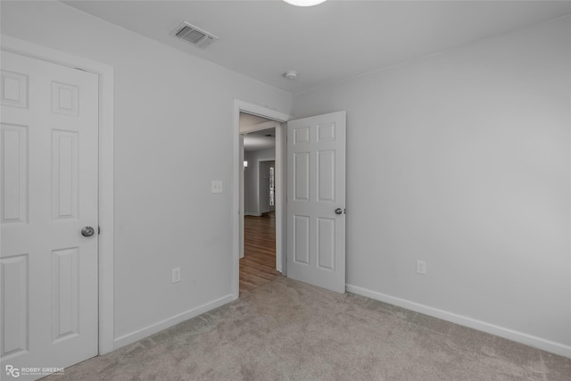 unfurnished bedroom featuring visible vents, baseboards, and carpet