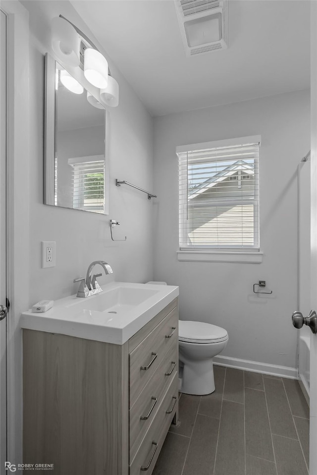 bathroom featuring tile patterned floors, toilet, vanity, and baseboards