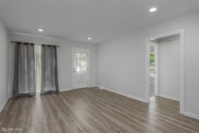 interior space featuring baseboards, recessed lighting, wood finished floors, and a healthy amount of sunlight