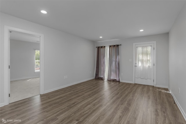unfurnished room featuring wood finished floors, baseboards, and recessed lighting