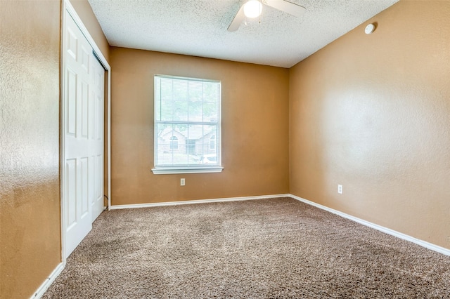 unfurnished bedroom featuring a ceiling fan, carpet floors, a textured ceiling, and a closet