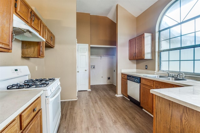 kitchen with a sink, white range with gas stovetop, brown cabinetry, light wood-type flooring, and dishwashing machine