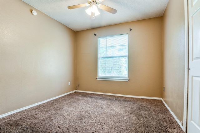 carpeted empty room featuring a textured ceiling, ceiling fan, and baseboards
