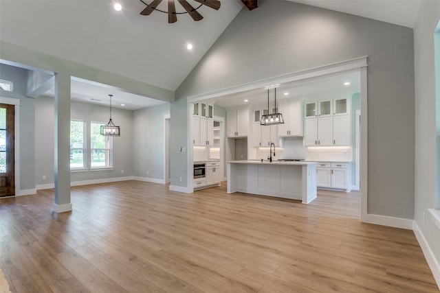 3822 Evergreen Ln, Caddo Mills, TX 75135 - unfurnished living room featuring a sink, high vaulted ceiling, light wood-type flooring, baseboards, and recessed lighting