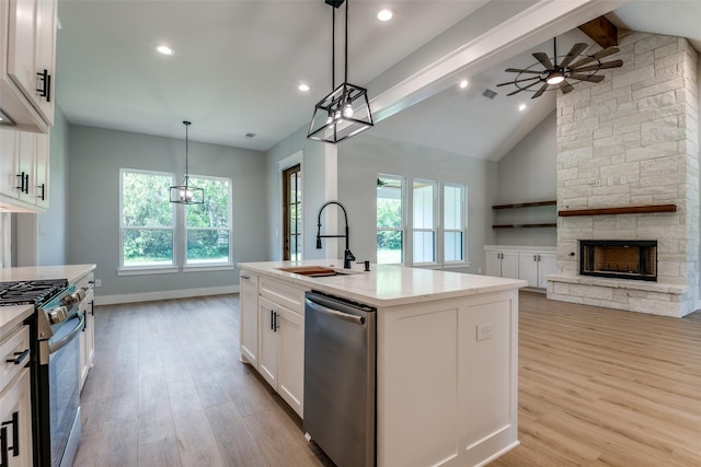 3822 Evergreen Ln, Caddo Mills, TX 75135 - kitchen featuring stainless steel appliances, a sink, open floor plan, ceiling fan, and light wood-style floors