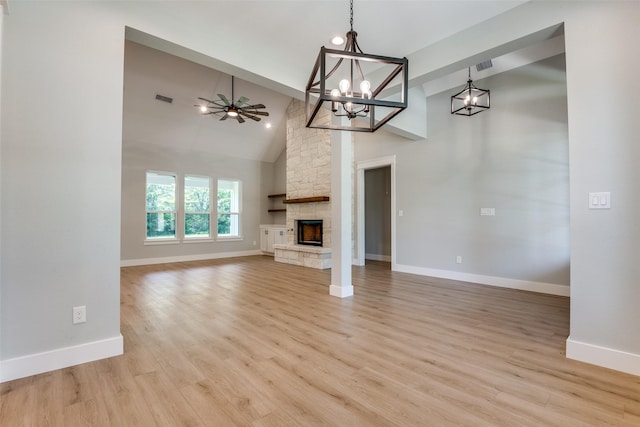 3822 Evergreen Ln, Caddo Mills, TX 75135 - unfurnished living room featuring baseboards, a chandelier, a ceiling fan, light wood-type flooring, and a stone fireplace