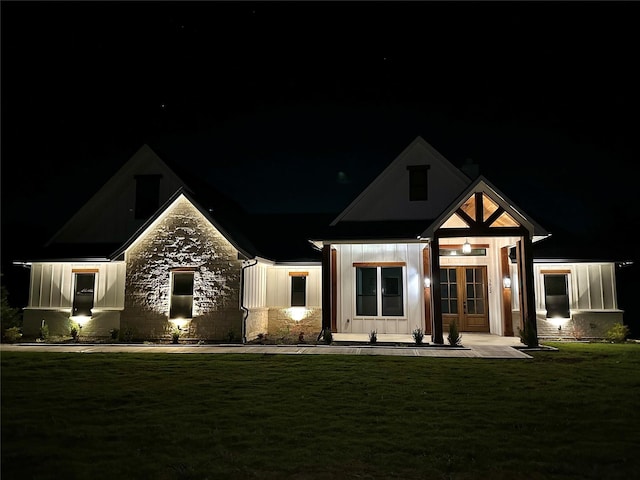 3822 Evergreen Ln, Caddo Mills, TX 75135 - view of front facade with board and batten siding, a lawn, french doors, and stone siding