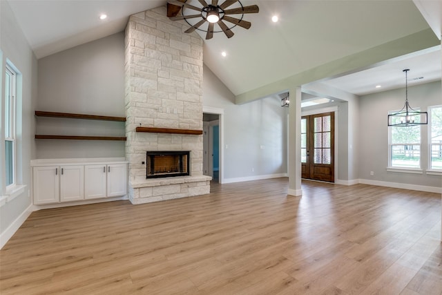 3822 Evergreen Ln, Caddo Mills, TX 75135 - unfurnished living room with a ceiling fan, a stone fireplace, light wood finished floors, baseboards, and high vaulted ceiling