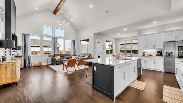 kitchen featuring visible vents, high vaulted ceiling, white cabinets, open floor plan, and stainless steel appliances