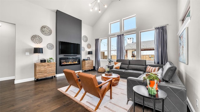 living area featuring plenty of natural light, high vaulted ceiling, baseboards, and dark wood-type flooring