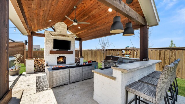 view of patio featuring a fenced backyard, outdoor wet bar, an outdoor kitchen, and area for grilling