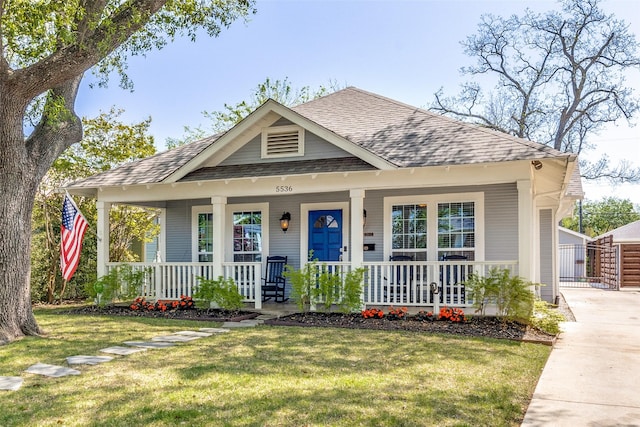 bungalow-style home featuring a porch, a shingled roof, and a front lawn