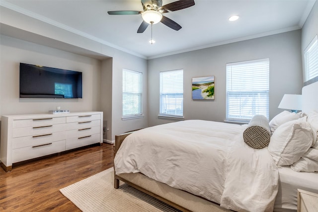 bedroom with dark wood-style floors, multiple windows, and ornamental molding