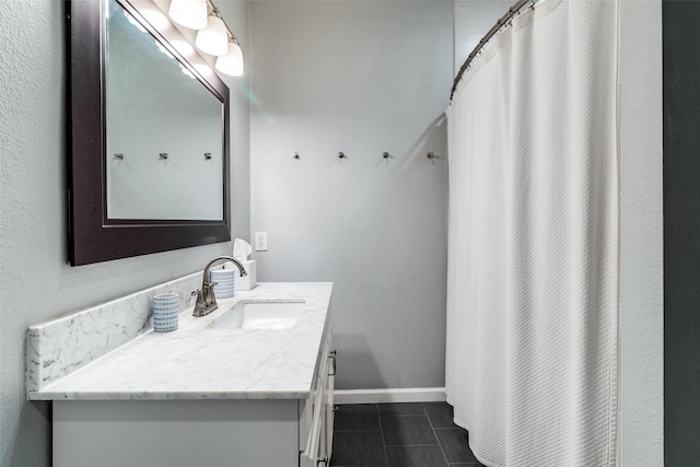 bathroom featuring baseboards, tile patterned flooring, and vanity