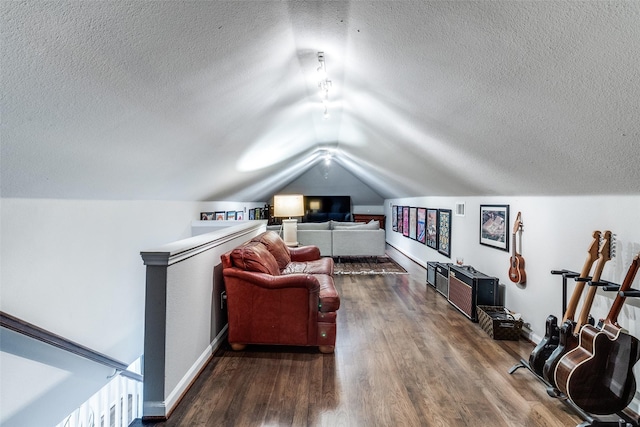 sitting room with dark wood-type flooring, a textured ceiling, baseboards, and lofted ceiling