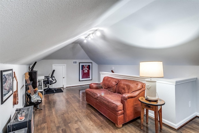 living area with visible vents, baseboards, a textured ceiling, vaulted ceiling, and wood finished floors