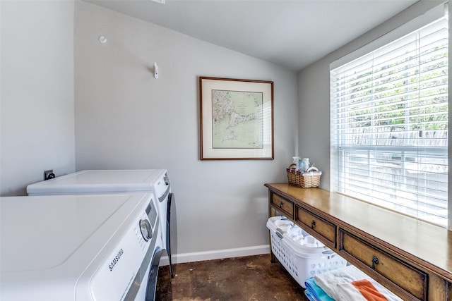 washroom featuring laundry area, washing machine and clothes dryer, and baseboards