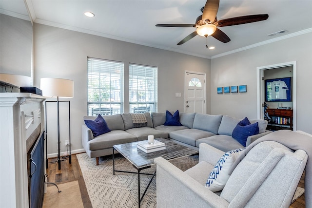 living area featuring visible vents, ornamental molding, and ceiling fan