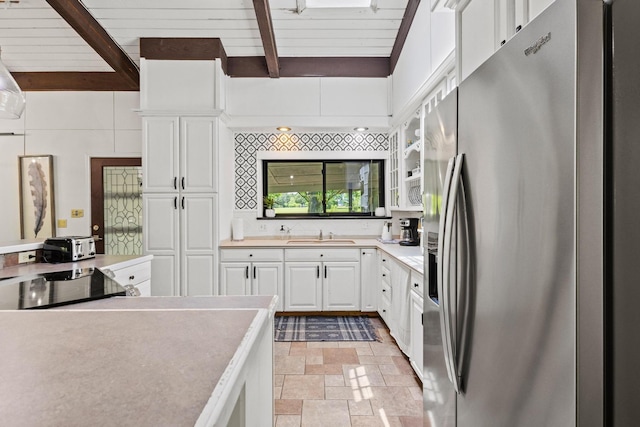 336 Kirk Ave, Pottsboro, TX 75076 - kitchen with white cabinets, beamed ceiling, stone finish floor, stainless steel fridge with ice dispenser, and light countertops