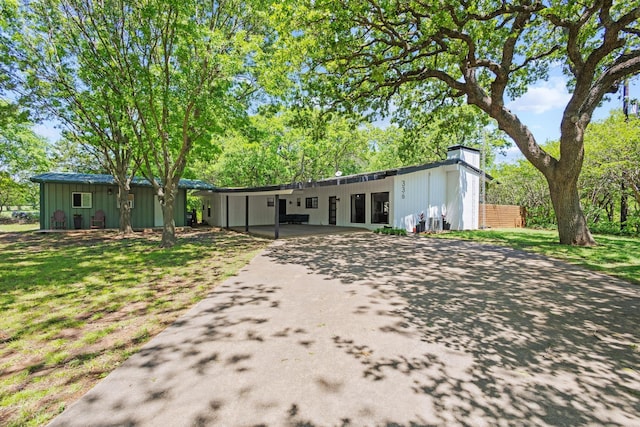 336 Kirk Ave, Pottsboro, TX 75076 - ranch-style home with board and batten siding, a chimney, and aphalt driveway