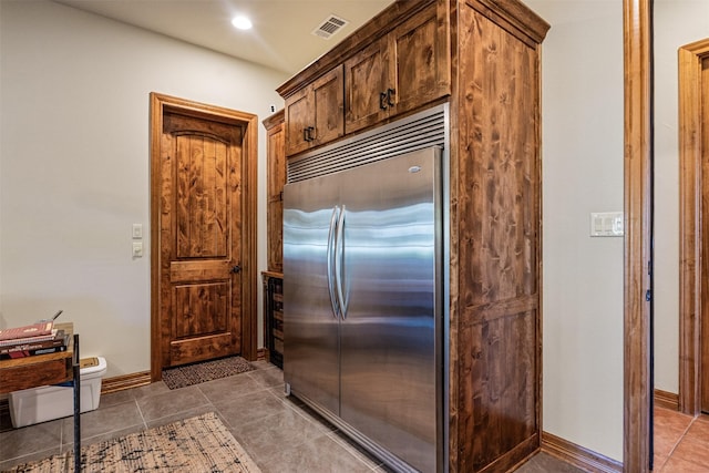 kitchen featuring built in refrigerator, tile patterned flooring, visible vents, recessed lighting, and baseboards