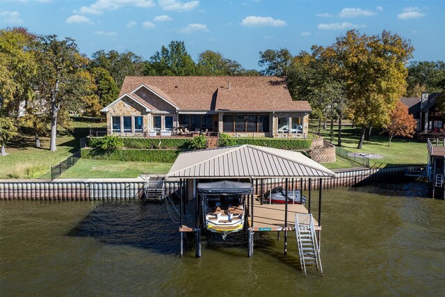 view of dock with a water view, a yard, and boat lift