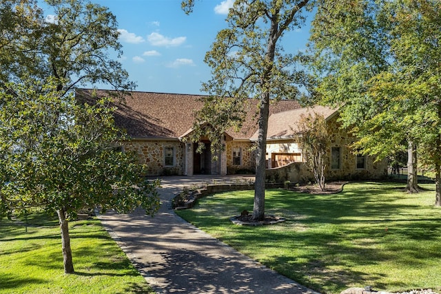 view of front of property featuring stone siding and a front lawn