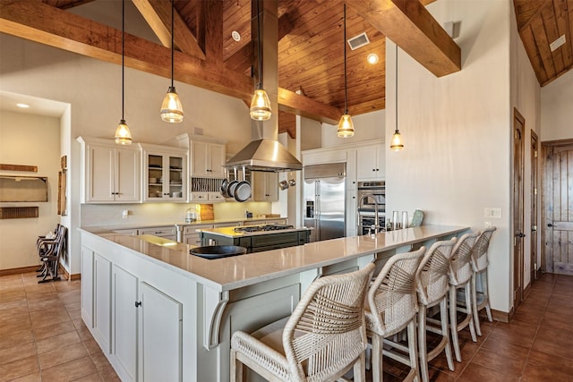 kitchen featuring stainless steel appliances, high vaulted ceiling, and beamed ceiling