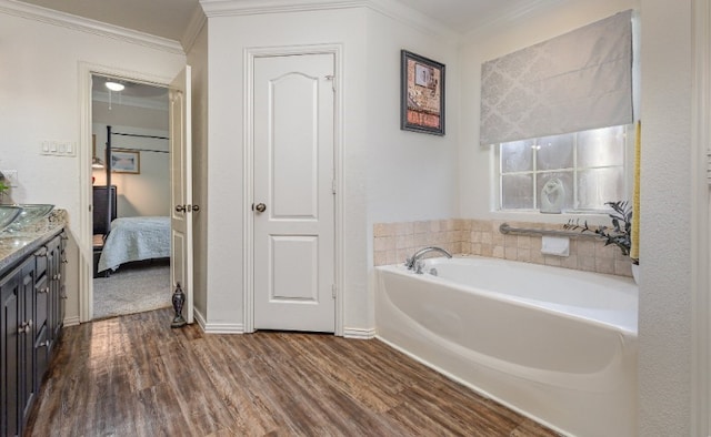 bathroom with vanity, ornamental molding, connected bathroom, a bath, and wood finished floors