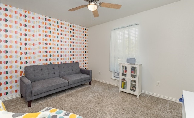 living area with ceiling fan, carpet, and baseboards
