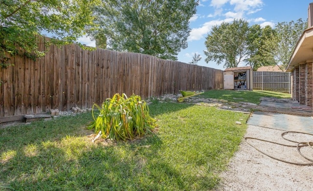 view of yard featuring an outbuilding, a fenced backyard, and a shed