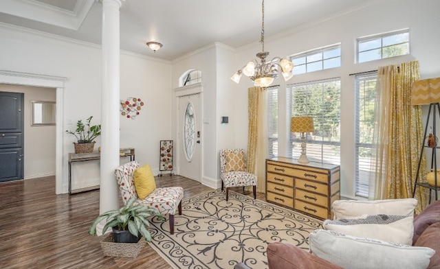 sitting room with a chandelier, ornate columns, ornamental molding, and wood finished floors