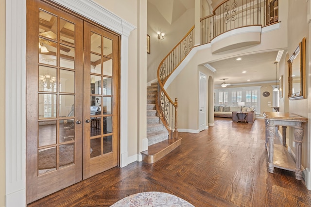 entryway featuring crown molding, stairs, a high ceiling, french doors, and baseboards