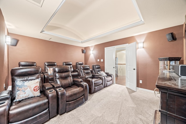 carpeted home theater with visible vents, a textured wall, baseboards, and a tray ceiling