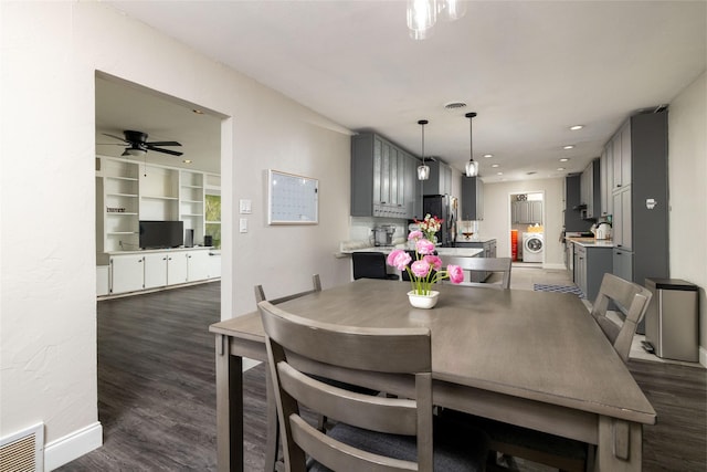 dining space featuring independent washer and dryer, dark wood finished floors, and visible vents