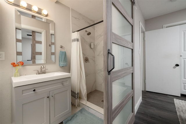 bathroom with vanity, a stall shower, and wood finished floors