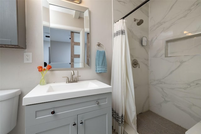 bathroom with toilet, a shower stall, and vanity