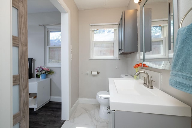 bathroom with marble finish floor, vanity, baseboards, and toilet