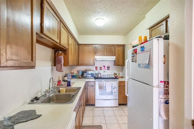 kitchen featuring brown cabinets, under cabinet range hood, light countertops, a sink, and white appliances