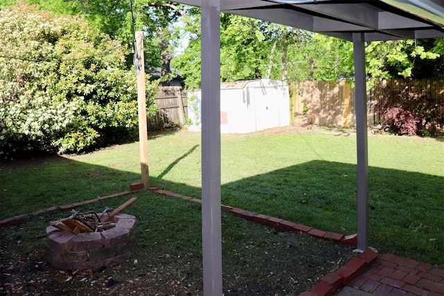 view of yard featuring a storage unit, a fenced backyard, and an outdoor structure
