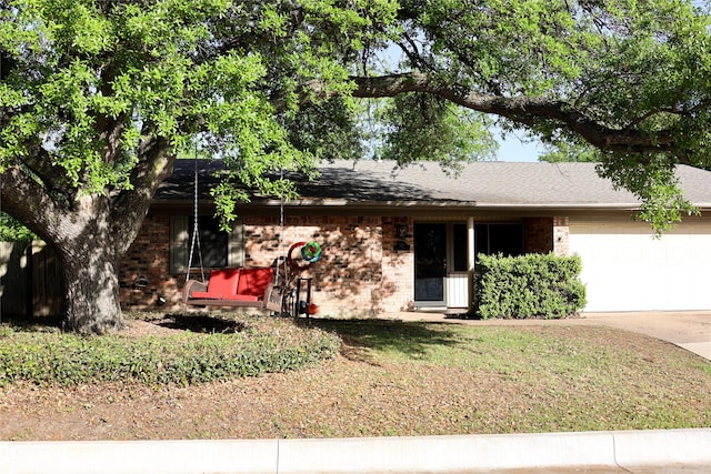 single story home featuring driveway, brick siding, and a garage